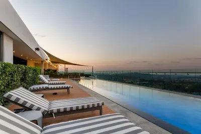 a building with a balcony with a swimming pool at Alimama Spaces: Koketso's Menlyn Maine in Pretoria