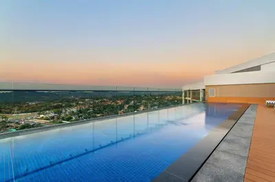 a large swimming pool with a view of a city at Alimama Spaces: Koketso's Menlyn Maine in Pretoria