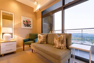 a living room with a couch and a window at Alimama Spaces: Koketso's Menlyn Maine in Pretoria