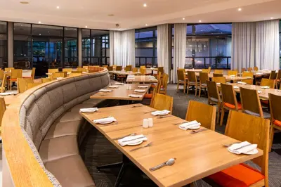a dining room with wooden tables and chairs at aha Kopanong Hotel & Conference Centre in Bredell