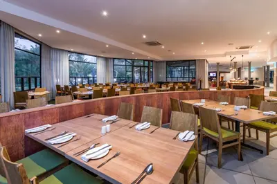 a dining room with wooden tables and chairs at aha Kopanong Hotel & Conference Centre in Bredell