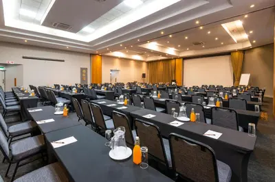 a conference room with black tables and chairs at aha Kopanong Hotel & Conference Centre in Bredell