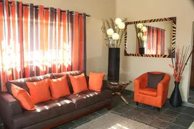 a living room with a brown leather couch and a chair at Destiny Lodge in White River