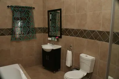 a bathroom with a toilet and a sink and a mirror at Destiny Lodge in White River