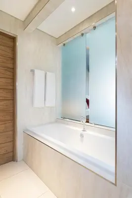 a bathroom with a large tub and a mirror at Menlyn Boutique Hotel in Pretoria