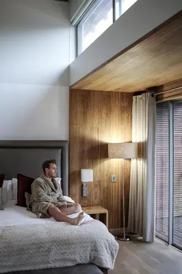 a man sitting on a bed in a bedroom at Menlyn Boutique Hotel in Pretoria