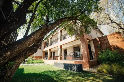 a building with a tree in front of it at Menlyn Boutique Hotel in Pretoria