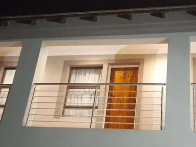 a house with a balcony with a door and windows at TLZ Prop B&B in Pretoria