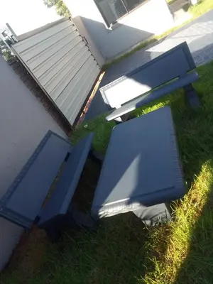 two blue benches sitting in the grass next to a building at TLZ Prop B&B in Pretoria