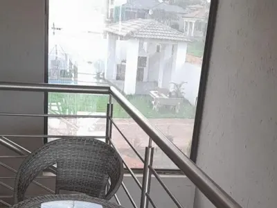 a wicker chair sitting on a balcony with a window at TLZ Prop B&B in Pretoria