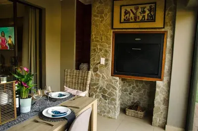 a dining room with a table with a television on a wall at Serene Luxury retreat in Cullinan in Cullinan