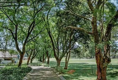 a path in a park with trees and a field at Serene Luxury retreat in Cullinan in Cullinan