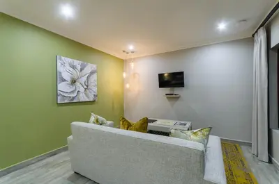 a living room with a couch and a tv at Nut Grove Boutique Hotel in White River
