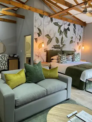 a living room with two beds and a couch at Nut Grove Boutique Hotel in White River