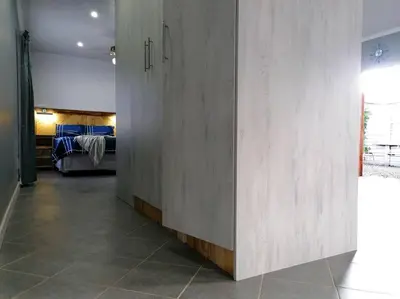 a hallway leading to a bedroom with a bed at Greystoke - Furnished, self service apartment. in Springs