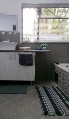 a bathroom with a sink and a tub and a window at Greystoke - Furnished, self service apartment. in Springs