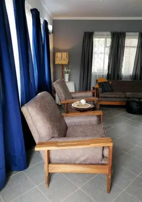 a living room with blue curtains and a couch at Greystoke - Furnished, self service apartment. in Springs