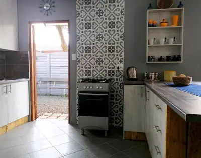 a kitchen with a stove and a tile wall at Greystoke - Furnished, self service apartment. in Springs