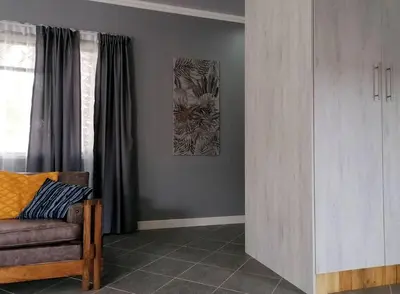 a living room with a couch and a painting on the wall at Greystoke - Furnished, self service apartment. in Springs
