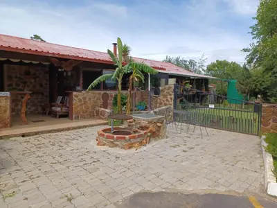 a patio with a fire pit in front of a house at KHAYA LANGA Guest House & Contractors Accommodation in Machadodorp