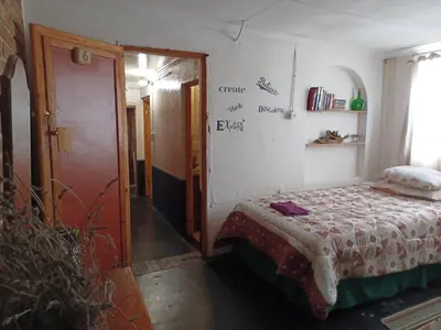 a small bedroom with a bed and a door at KHAYA LANGA Guest House & Contractors Accommodation in Machadodorp