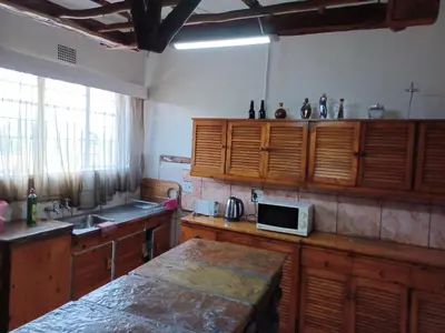 a kitchen with wooden cabinets and a white microwave at KHAYA LANGA Guest House & Contractors Accommodation in Machadodorp