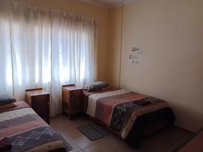 a bedroom with two twin beds and a window at KHAYA LANGA Guest House & Contractors Accommodation in Machadodorp