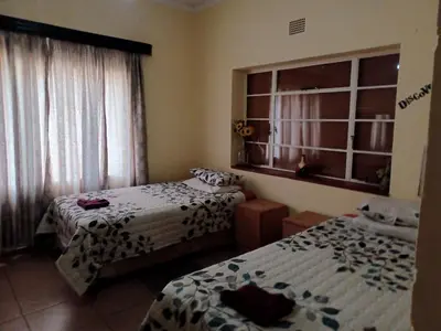 two beds in a room with a window and two bedsvisor at KHAYA LANGA Guest House & Contractors Accommodation in Machadodorp