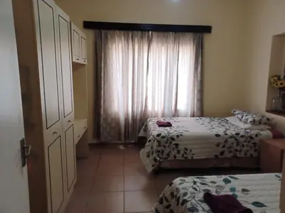 a small room with two beds and a window at KHAYA LANGA Guest House & Contractors Accommodation in Machadodorp
