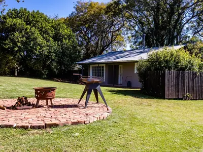 a fire pit in a yard next to a house at Wellstead Country Manor in Haenertsburg