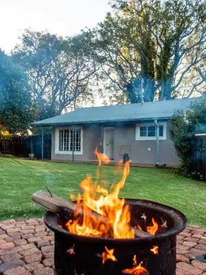 a fire pit in a yard in front of a house at Wellstead Country Manor in Haenertsburg