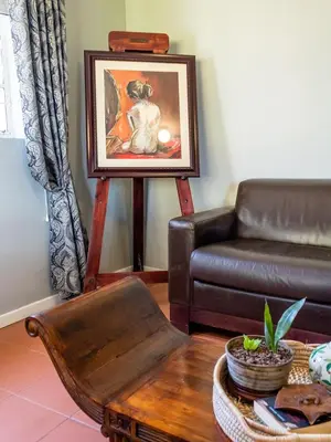 a living room with a leather couch and a picture at Wellstead Country Manor in Haenertsburg