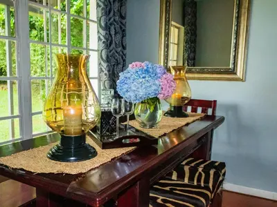 a table with two vases and flowers on it at Wellstead Country Manor in Haenertsburg