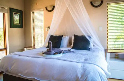 a bedroom with a white bed with a canopy at Buhala @ 411 in Hoedspruit