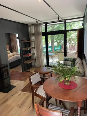 a living room with tables and chairs and a couch at TWO Prefab Living - Luxury bungalows in Dullstroom