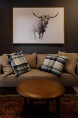 a living room with a couch with a picture of a bull at TWO Prefab Living - Luxury bungalows in Dullstroom