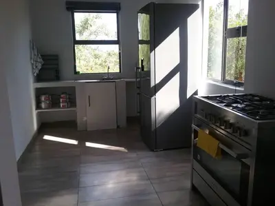 a kitchen with a stove and a kitchen with a window at Thuto Centre Conferencing & Bush Lodge in Bela-Bela