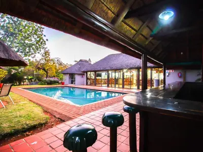 a house with a swimming pool and a building at Thuto Centre Conferencing & Bush Lodge in Bela-Bela