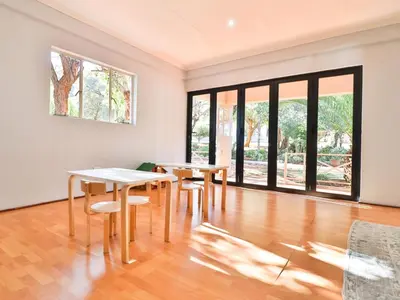 a room with two tables and chairs and windows at Thuto Centre Conferencing & Bush Lodge in Bela-Bela