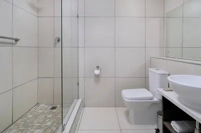 a bathroom with a shower and a toilet and a sink at Protea Hotel by Marriott Polokwane Landmark in Polokwane