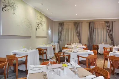 a dining room with white tables and chairs at Protea Hotel by Marriott Polokwane Landmark in Polokwane