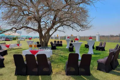a table set up for a wedding under a tree at Protea Hotel by Marriott Polokwane Landmark in Polokwane
