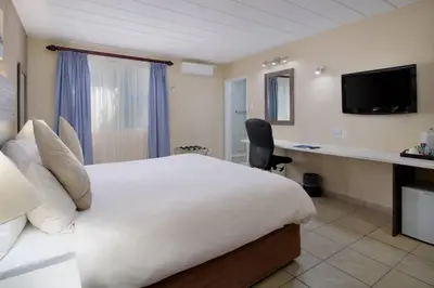 a hotel room with a bed and a desk at Protea Hotel by Marriott Polokwane Landmark in Polokwane