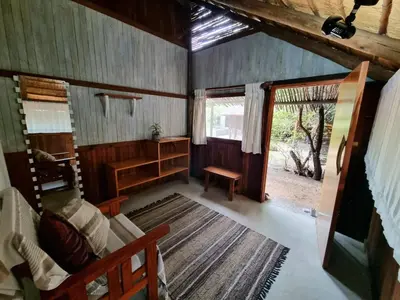 a living room with a couch and a table and a window at Off Beat Safaris Bush Lodge in Hoedspruit