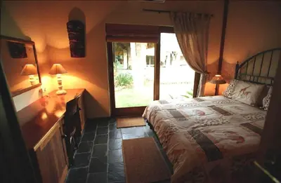 a bedroom with a large bed and a window at Khandizwe Kruger Villa in Malelane
