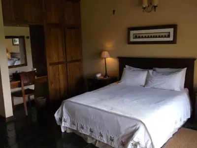 a bedroom with a large bed with white sheets and pillows at Khandizwe Kruger Villa in Malelane