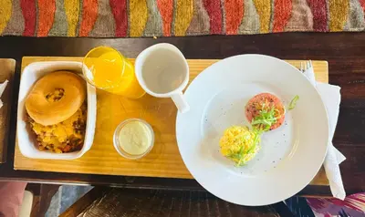 a table with two plates of food and a bowl of orange juice at Khandizwe Kruger Villa in Malelane