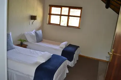 a hotel room with two beds and a window at Kruger Park Lodge - Golf Safari SA in Hazyview
