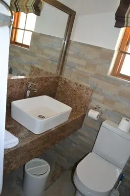 a bathroom with a sink and a toilet at Kruger Park Lodge - Golf Safari SA in Hazyview