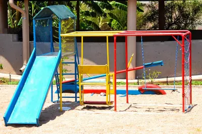 a playground with colorful playground equipment in the sand at Makobaneng Guesthouse in Ga-Raphokola